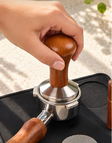 Tamping the coffee bed with the tamper
