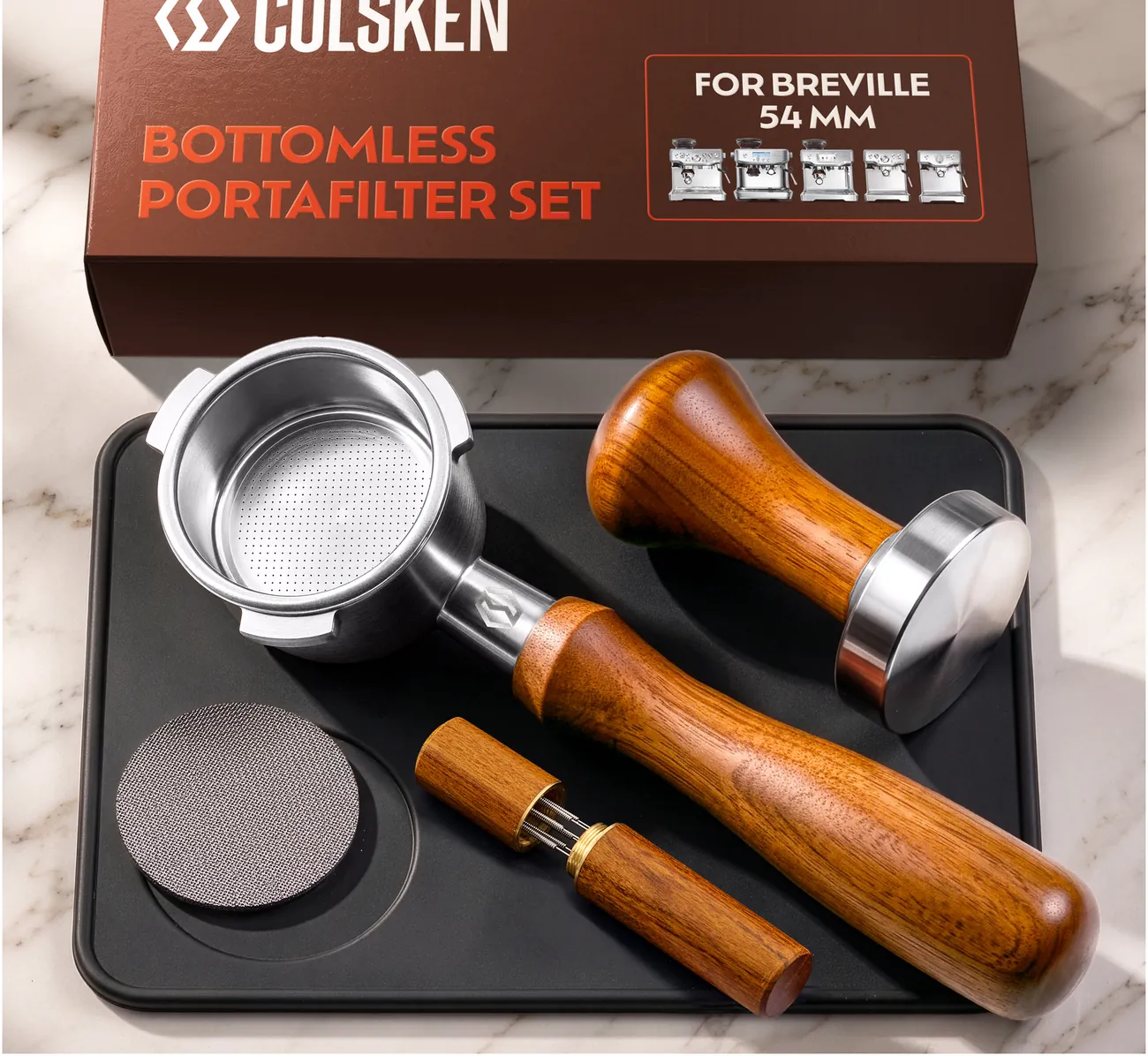 The COLSKEN 54mm kit on marble: bottomless portafilter with wood handle, tamper, puck screen, WDT tool, silicone tamping mat and gift box